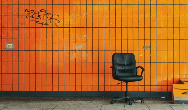 Karriere Trainingsprogramm - Institut für moderne Führung - mentale Begleitung zum Erfolg - Orange Fliesenwand mit schwarzem Drehstuhl
